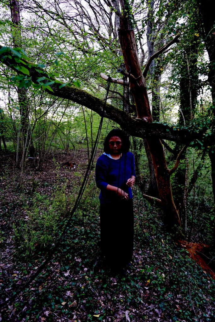 Installation de ficelles en laine noire, avec parfois, ma silhouette, dans la forêt