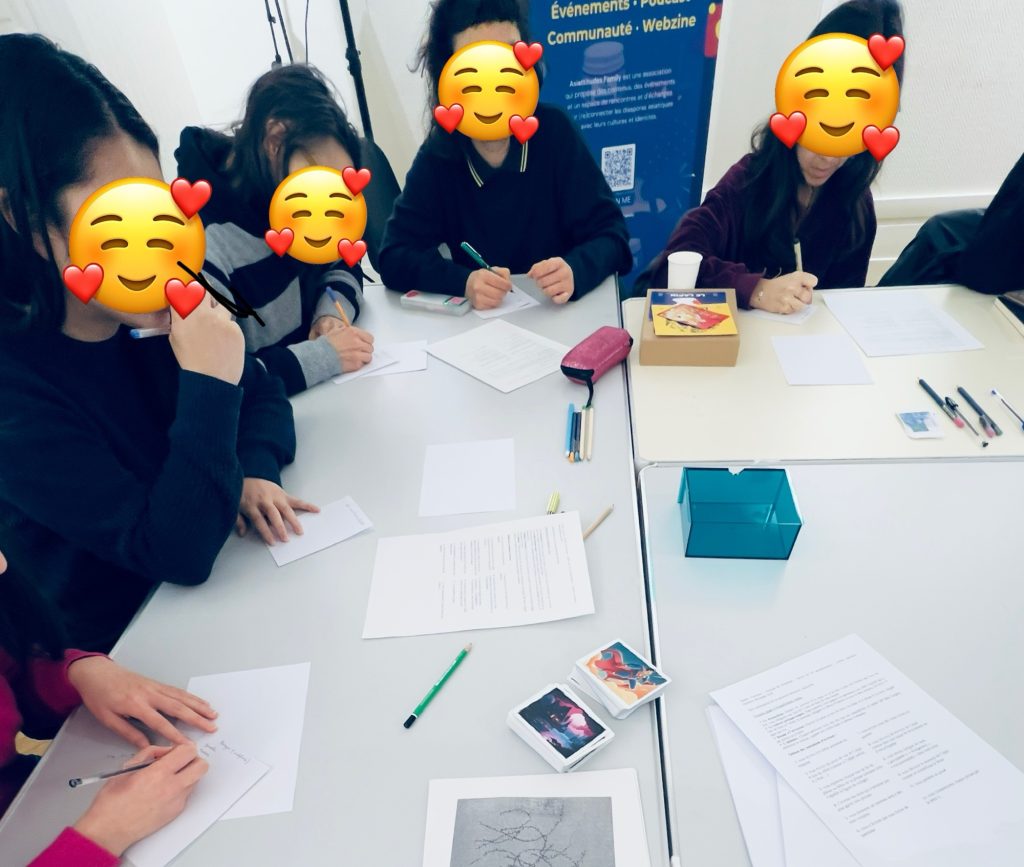 Cette photo décrit un groupe de personnes en train d’écrire sur une table blanche avec des crayons et du papier​