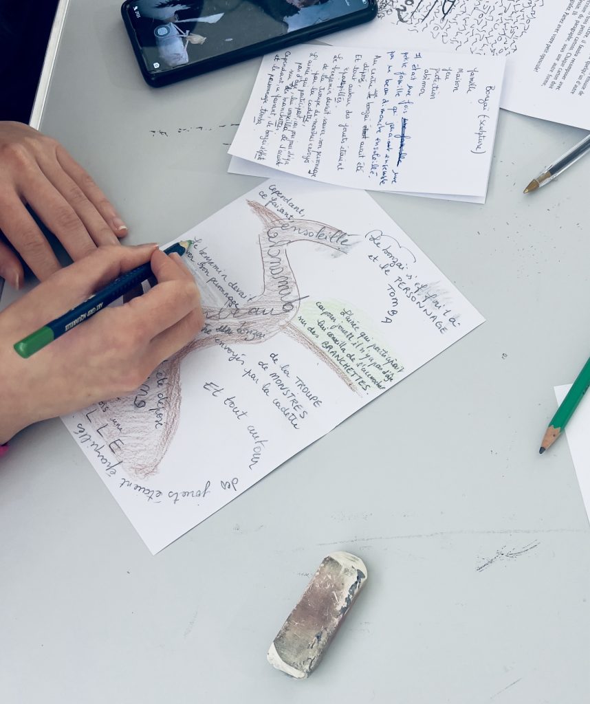 Photo d’une participante dont on voit seulement les mains et le stylo en train d’écrire sur un papier blanc